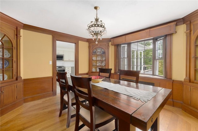 2 Carvin Ct, Warwick, RI 02886 - dining space with light wood finished floors, a chandelier, wainscoting, and ornamental molding