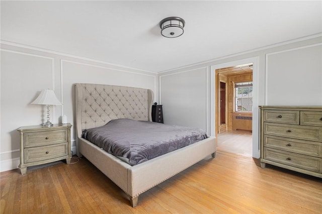 2 Carvin Ct, Warwick, RI 02886 - bedroom with radiator, a decorative wall, light wood-style floors, and ornamental molding