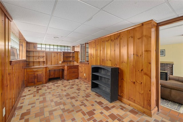2 Carvin Ct, Warwick, RI 02886 - unfurnished office with a brick fireplace, wood walls, and a drop ceiling