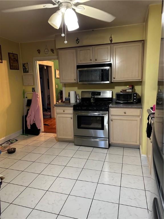 53 Wampanoag Trl, East Providence, RI 02915 - kitchen featuring stainless steel appliances, dark countertops, a ceiling fan, and light tile patterned flooring