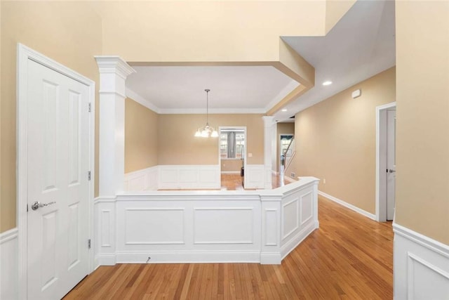 156 Hampton Way S, Kingstown, RI 02879 - hall featuring ornate columns, a wainscoted wall, light wood-style flooring, a decorative wall, and ornamental molding