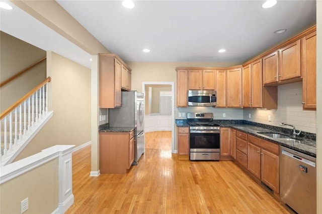 156 Hampton Way S, Kingstown, RI 02879 - kitchen with stainless steel appliances, a sink, light wood-type flooring, dark stone countertops, and backsplash
