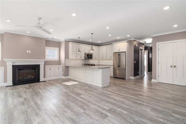 23 Middleberry Ln, East Greenwich, RI 02818 - kitchen with stainless steel appliances, crown molding, a peninsula, open floor plan, and a ceiling fan