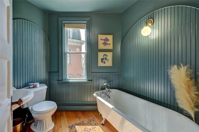 384 Benefit St Unit 2, Providence, RI 02903 - bathroom with baseboard heating, a freestanding bath, toilet, wood finished floors, and wainscoting