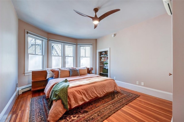 384 Benefit St Unit 2, Providence, RI 02903 - bedroom with a baseboard heating unit, baseboards, wood finished floors, ceiling fan, and a wall unit AC