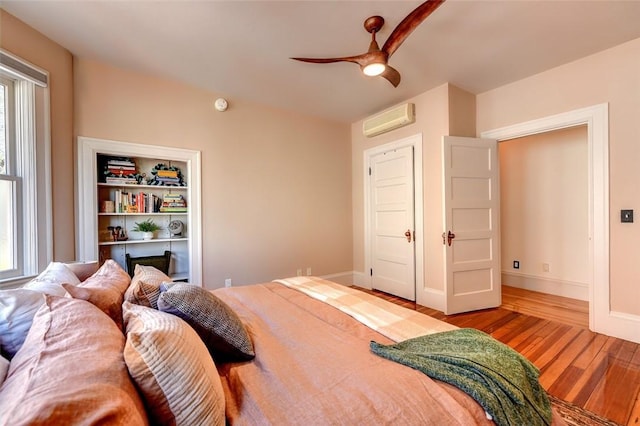 384 Benefit St Unit 2, Providence, RI 02903 - bedroom with an AC wall unit, wood finished floors, baseboards, and a ceiling fan