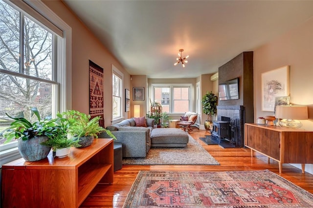 384 Benefit St Unit 2, Providence, RI 02903 - living area with wood finished floors, a wood stove, and a chandelier