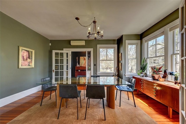 384 Benefit St Unit 2, Providence, RI 02903 - dining area featuring a chandelier, healthy amount of natural light, a wall unit AC, and wood finished floors