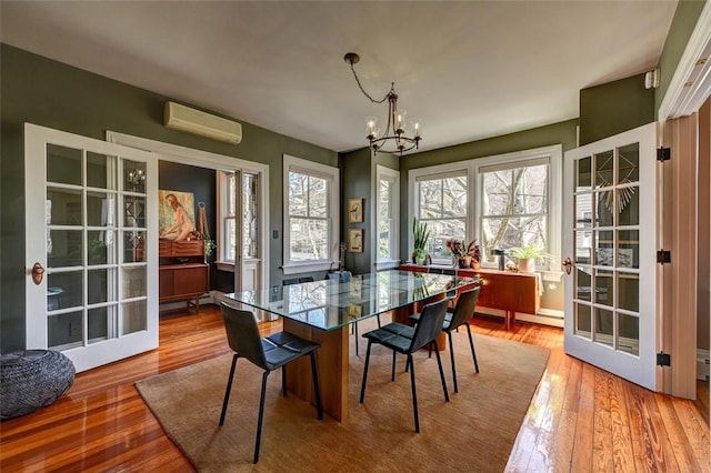 384 Benefit St Unit 2, Providence, RI 02903 - dining room featuring a wall mounted AC, a chandelier, and light wood-type flooring