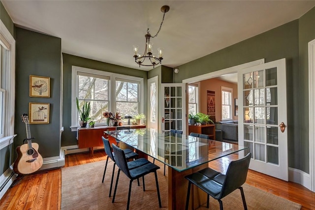 384 Benefit St Unit 2, Providence, RI 02903 - dining space featuring a chandelier, wood finished floors, and baseboards