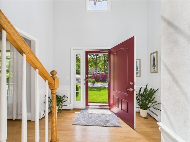 64 E Park Ln, South Kingstown, RI 02879 - foyer entrance featuring a high ceiling, wood finished floors, stairs, and a baseboard radiator
