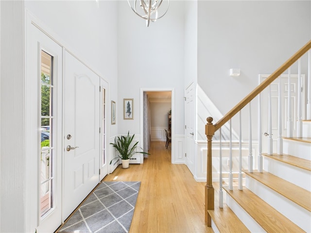 64 E Park Ln, South Kingstown, RI 02879 - foyer entrance with a towering ceiling, light wood finished floors, a chandelier, and stairs