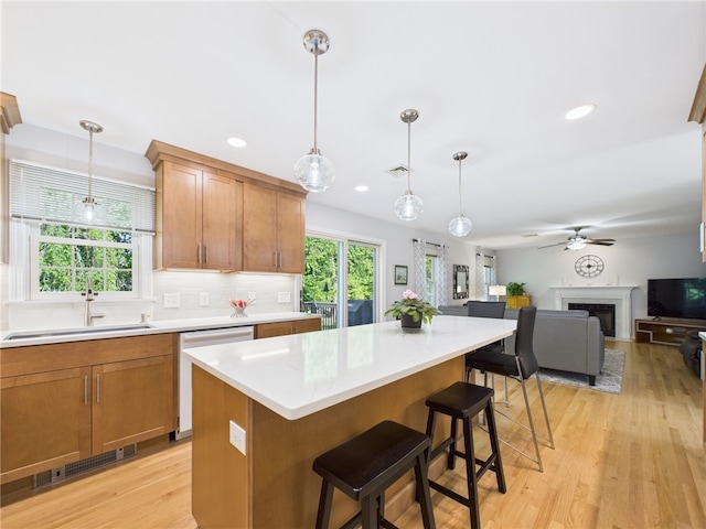 64 E Park Ln, South Kingstown, RI 02879 - kitchen with white dishwasher, light countertops, light wood-type flooring, ceiling fan, and open floor plan