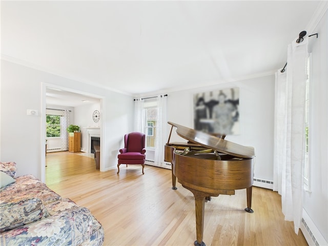 64 E Park Ln, South Kingstown, RI 02879 - living area with baseboard heating, a baseboard heating unit, light wood-type flooring, and crown molding
