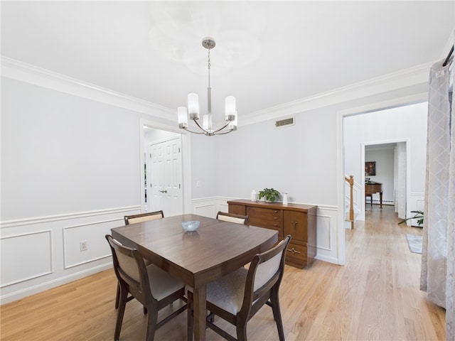 64 E Park Ln, South Kingstown, RI 02879 - dining area featuring a chandelier, ornamental molding, a decorative wall, light wood-style flooring, and a wainscoted wall