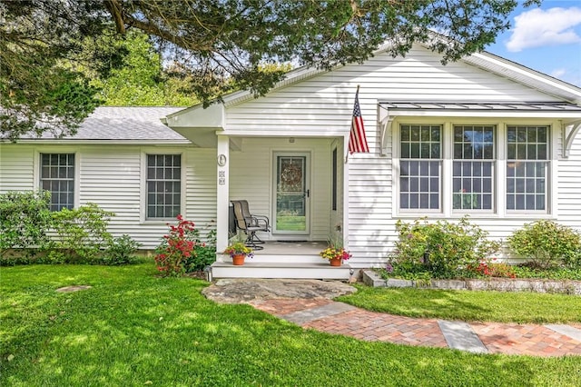 22 Pond View Dr, Little Compton, RI 02837 - view of front facade with covered porch, a front yard, and a shingled roof