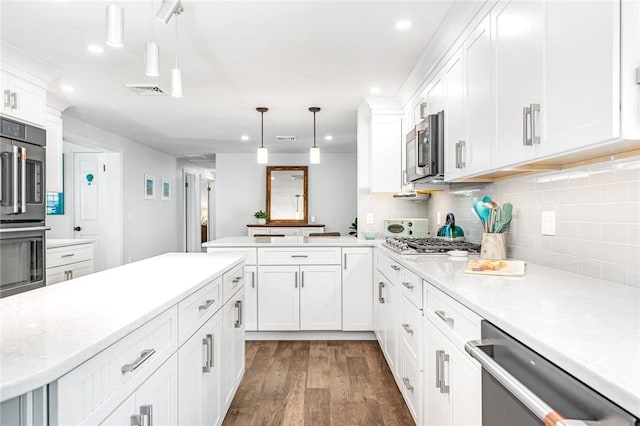 22 Pond View Dr, Little Compton, RI 02837 - kitchen with stainless steel appliances, dark wood-style floors, light countertops, decorative backsplash, and a peninsula