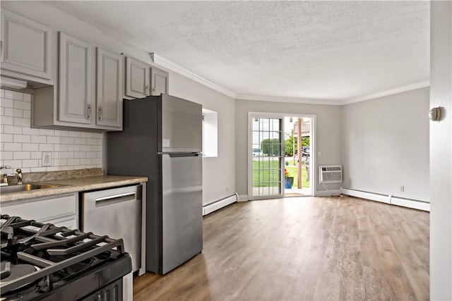 3940 Post Rd Unit 38, Warwick, RI 02886 - kitchen featuring baseboard heating, appliances with stainless steel finishes, a textured ceiling, crown molding, and decorative backsplash