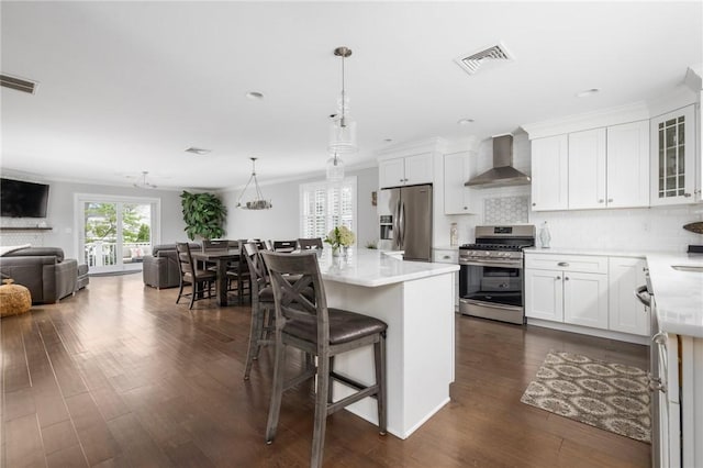 36 Wanda St, Narragansett, RI 02882 - kitchen featuring appliances with stainless steel finishes, wall chimney exhaust hood, open floor plan, light countertops, and crown molding