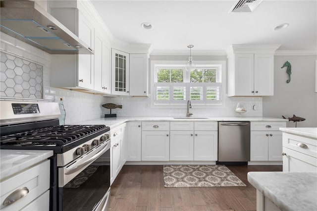 36 Wanda St, Narragansett, RI 02882 - kitchen with stainless steel appliances, a sink, wall chimney range hood, light countertops, and ornamental molding