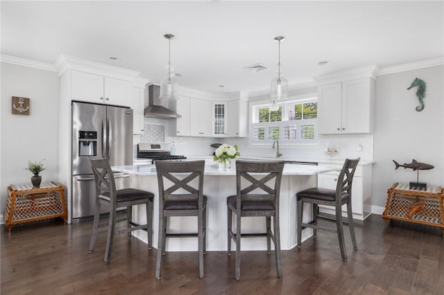 36 Wanda St, Narragansett, RI 02882 - kitchen with appliances with stainless steel finishes, wall chimney range hood, light countertops, a center island, and white cabinets