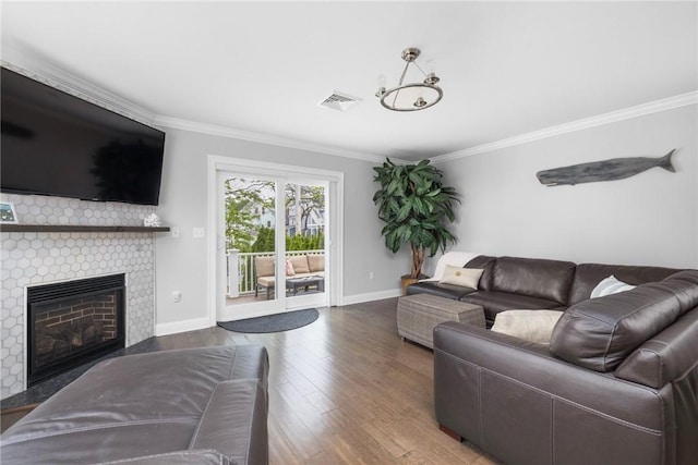 36 Wanda St, Narragansett, RI 02882 - living room featuring ornamental molding, a glass covered fireplace, wood finished floors, baseboards, and a chandelier