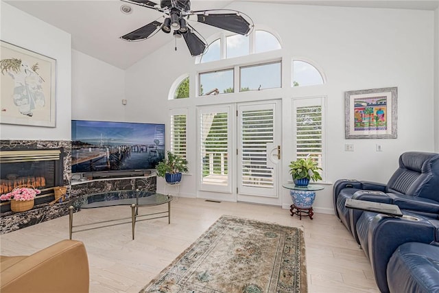 48 Wright Ln, Jamestown, RI 02835 - living room with ceiling fan, wood finished floors, a fireplace, baseboards, and high vaulted ceiling