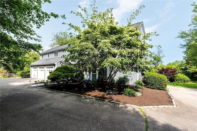 48 Wright Ln, Jamestown, RI 02835 - view of property hidden behind natural elements featuring an attached garage and driveway