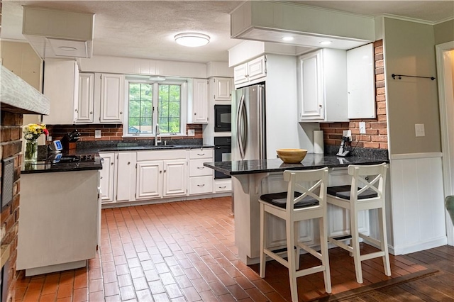850 Black Plain Rd, North Smithfield, RI 02896 - kitchen with a peninsula, black appliances, dark countertops, white cabinets, and wainscoting