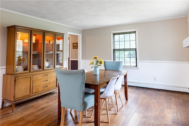 850 Black Plain Rd, North Smithfield, RI 02896 - dining space featuring baseboard heating, wainscoting, hardwood / wood-style floors, and ornamental molding