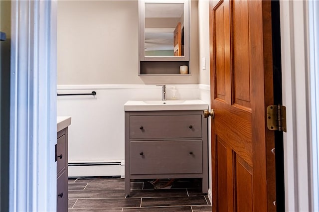 850 Black Plain Rd, North Smithfield, RI 02896 - bathroom with vanity, a baseboard heating unit, and wood finish floors