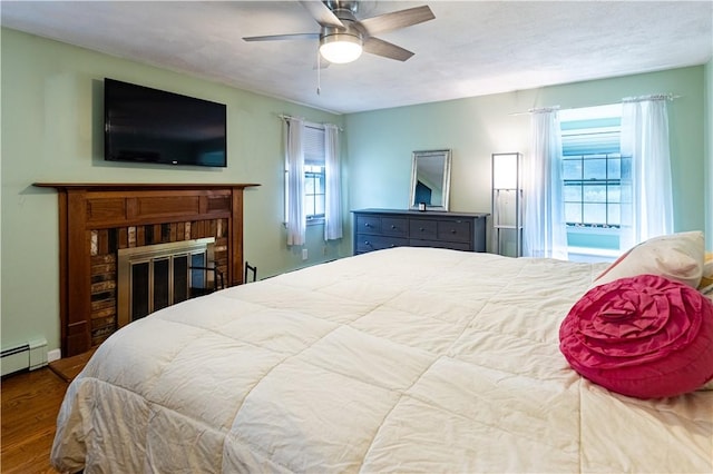 850 Black Plain Rd, North Smithfield, RI 02896 - bedroom featuring wood finished floors, a brick fireplace, and a ceiling fan