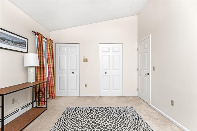 565 Quaker Ln Unit 43, West Warwick, RI 02893 - bedroom with vaulted ceiling, light colored carpet, baseboards, and a baseboard heating unit