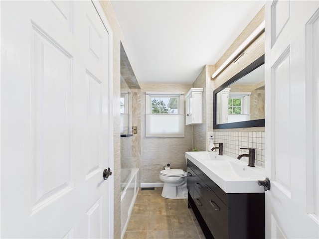 6 Dolphin Rd, Narragansett, RI 02882 - bathroom with plenty of natural light, double vanity, toilet, tile patterned flooring, and tile walls