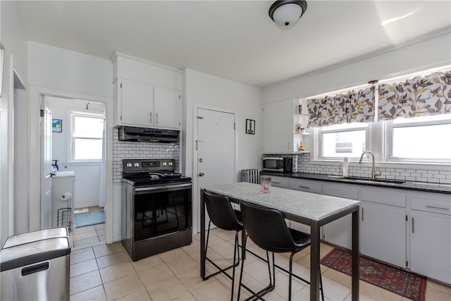 412 E Ave, Pawtucket, RI 02860 - kitchen with black range with electric stovetop, a sink, stainless steel microwave, under cabinet range hood, and backsplash