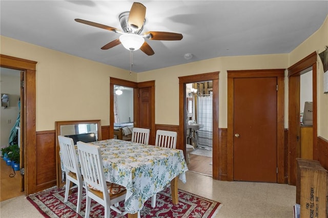 99 Third St, West Warwick, RI 02893 - dining room featuring wainscoting, a ceiling fan, light flooring, and wood walls