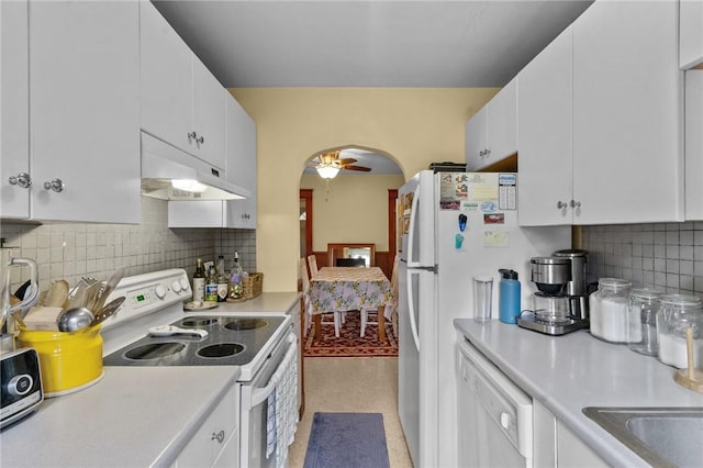 99 Third St, West Warwick, RI 02893 - kitchen with white appliances, under cabinet range hood, light countertops, arched walkways, and white cabinetry