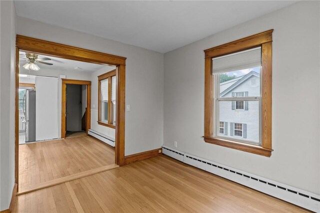99 Third St, West Warwick, RI 02893 - empty room with a baseboard heating unit, light wood finished floors, baseboards, and a ceiling fan
