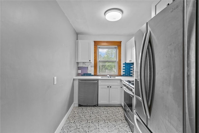 99 Third St, West Warwick, RI 02893 - kitchen featuring stainless steel appliances, white cabinetry, baseboards, light countertops, and a sink