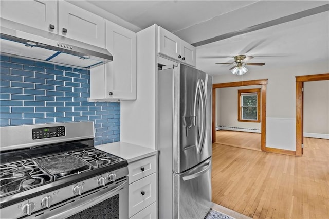 99 Third St, West Warwick, RI 02893 - kitchen with stainless steel appliances, a baseboard radiator, under cabinet range hood, a ceiling fan, and light countertops