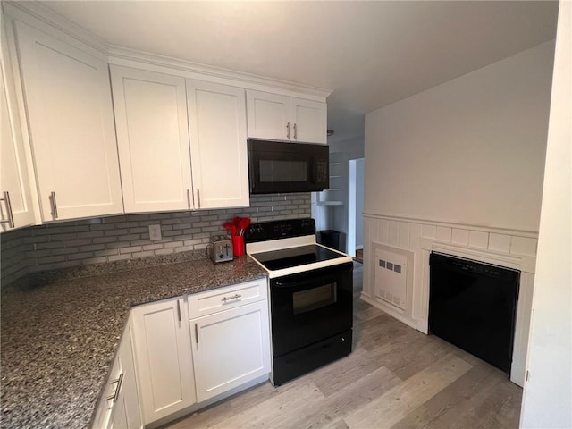 3506 Kingstown Rd, South Kingstown, RI 02892 - kitchen with black appliances, backsplash, white cabinetry, light wood-style floors, and dark stone countertops