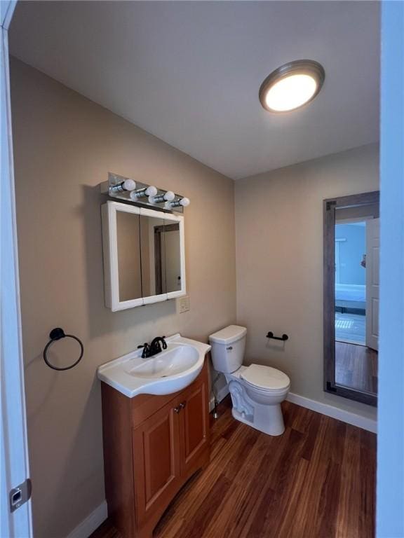 3506 Kingstown Rd, South Kingstown, RI 02892 - half bathroom with vanity, wood finished floors, toilet, and baseboards