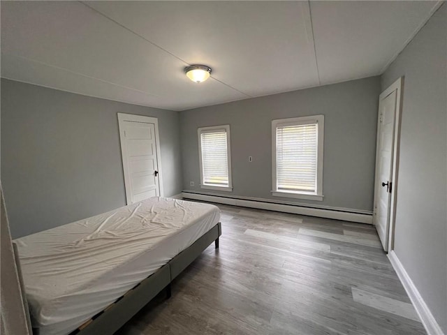 3506 Kingstown Rd, South Kingstown, RI 02892 - bedroom featuring a baseboard radiator, wood finished floors, and baseboards