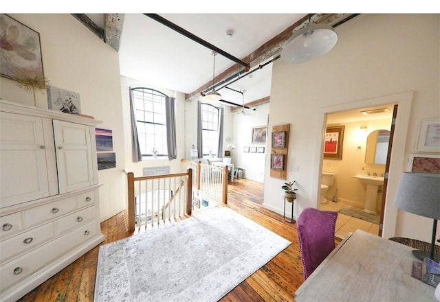 28 Bayley St N Unit 107, Pawtucket, RI 02860 - dining area with light wood-style floors, beam ceiling, arched walkways, and baseboards
