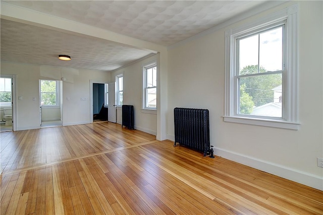 93 Naples Ave, Providence, RI 02908 - unfurnished living room featuring radiator, light wood-type flooring, and baseboards