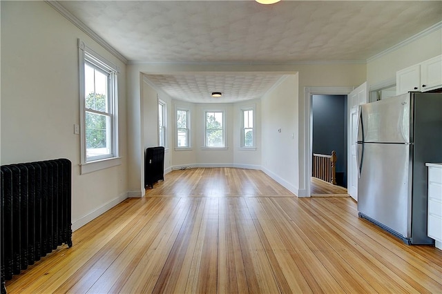 93 Naples Ave, Providence, RI 02908 - unfurnished dining area featuring radiator, light wood finished floors, baseboards, and crown molding