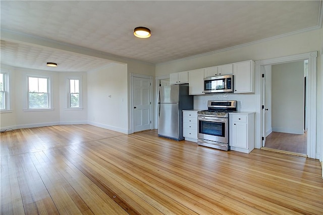 93 Naples Ave, Providence, RI 02908 - kitchen with appliances with stainless steel finishes, white cabinetry, baseboards, light wood-style flooring, and ornamental molding