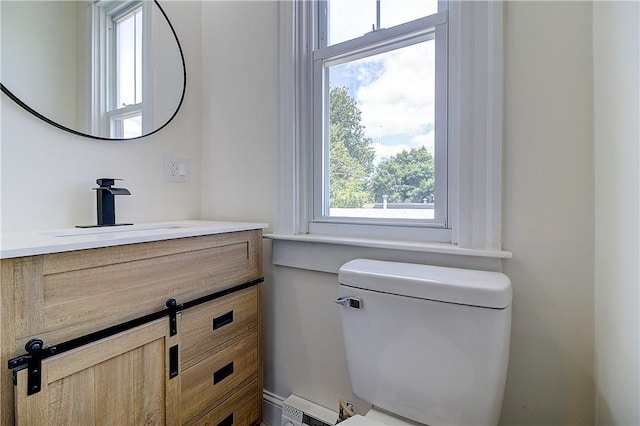 93 Naples Ave, Providence, RI 02908 - half bathroom featuring healthy amount of natural light, vanity, toilet, and baseboard heating