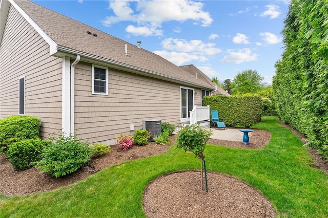 5 Leighas Ln, Coventry, RI 02816 - rear view of property featuring a patio, a lawn, roof with shingles, and central AC unit