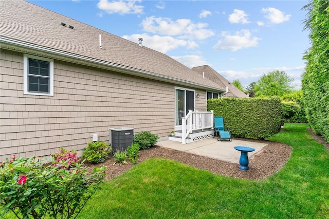 5 Leighas Ln, Coventry, RI 02816 - back of property featuring a patio area, a lawn, cooling unit, and a shingled roof